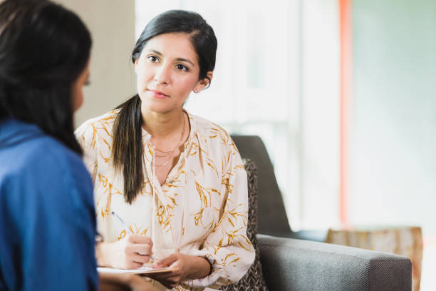 Psychologist listens and takes notes as a vulnerable patient discusses an important topic.